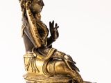 bronze statue of a woman sitting on a chair with her hands in the air