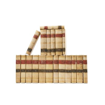 several old books stacked on top of each other on a white surface