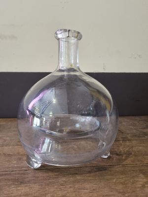 a clear glass bottle sitting on top of a wooden table