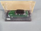a green toy car in a plastic box on a table