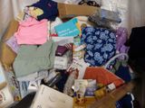 a box full of clothes and other items on a bed
