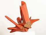 sculpture of a bird made of red clay on a white pedestal