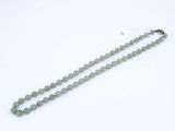 un collier de perles de jade vert muni d'un fermoir en or