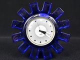 une horloge bleue posée sur une table noire