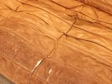 a brown leather couch sitting on top of a wooden floor