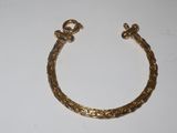 an image of a gold bracelet on a white surface