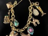 a close up of a gold bracelet with charms on it