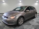 Une Volkswagen Golf grise est garée sur un sol carrelé à damier.