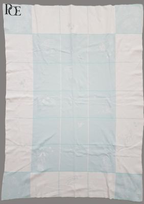 nappe à carreaux bleus et blancs sur fond gris, avec monogramme