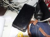 un téléphone portable posé sur un sac, à côté d'un ordinateur portable
