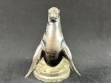 an image of a silver figurine of a bird on a pedestal