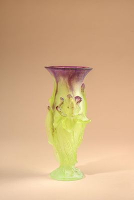 purple and green glass vase sitting on top of a white surface
