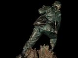 bronze statue of a man with a gun on a black background
