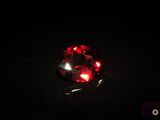 un gros plan sur un diamant rouge dans l'obscurité