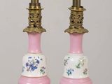 pair of pink and white lamps with floral designs on them on a table