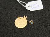 a close up of a tag and a pair of earrings on a black surface