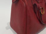 a close up of a red handbag on a white surface