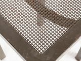 a metal table with a metal mesh top on a snow covered ground