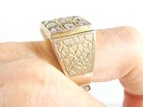 a man ' s hand holding a gold ring with a diamond on it