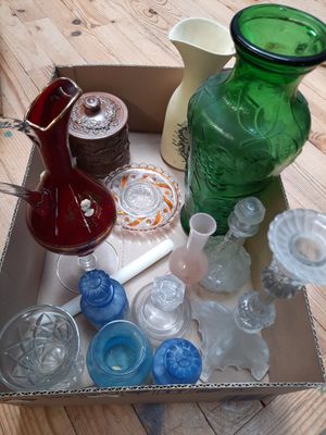 une boîte remplie d'objets en verre de différentes couleurs posée sur une table