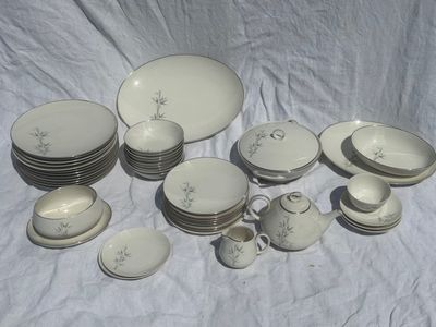 a lot of white dishes and cups on a table