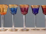 four wine glasses are lined up in a row on a table