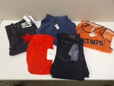 Plusieurs paires de jeans sont posées les unes à côté des autres sur une table.