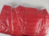 a plastic bag with a red jacket on it sitting on a table