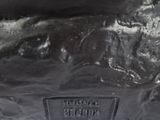a close up of a statue of a dog on a white surface