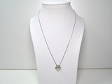 collier en argent avec un pendentif en forme de cœur sur un mannequin blanc