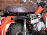 a red motorcycle parked in front of a brick wall