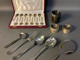 a lot of silver spoons and spoons in a case