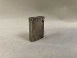 a small silver lighter sitting on a white surface