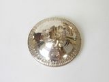 a silver plate with an angel on it on a white surface
