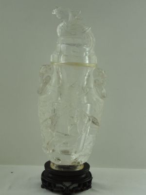 un vase en verre transparent avec un socle noir posé sur une table