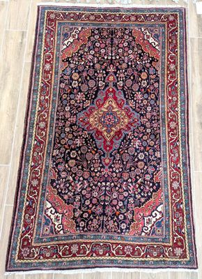 rug on the floor in a room with wooden flooring and white walls