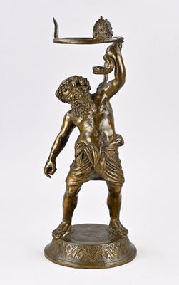 une statue antique en bronze représentant un homme tenant un plateau sur lequel repose un poisson