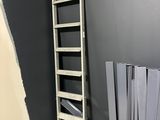 une échelle appuyée contre un mur noir dans une pièce