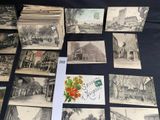 many old postcards on a table with a bunch of them
