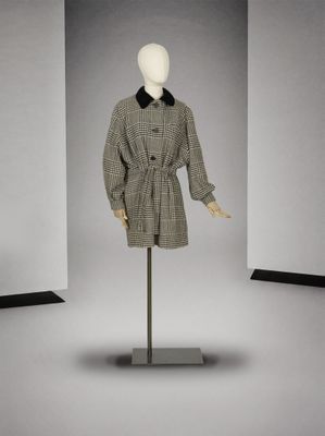 un mannequin portant un manteau à col noir, posé sur un support