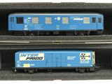 deux wagons bleus posés dans une boîte sur une surface blanche