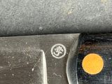a close up of a knife with a yellow dot on it