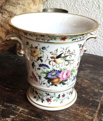 un vase avec un oiseau posé sur une table