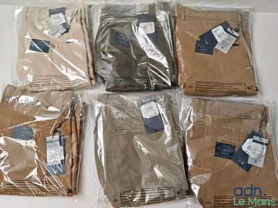 six pairs of men ' s pants in plastic bags on a table