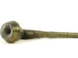 an old brass pipe sitting on top of a white surface