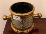 a gold and black vase sitting on a wooden table