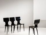 trois chaises noires dans une pièce blanche aux murs blancs