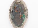 an old silver locke with a picture of a woman in a green dress