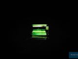 une image représentant une lumière verte qui brille sur une surface noire
