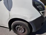 a small white car that is parked on the side of the road
